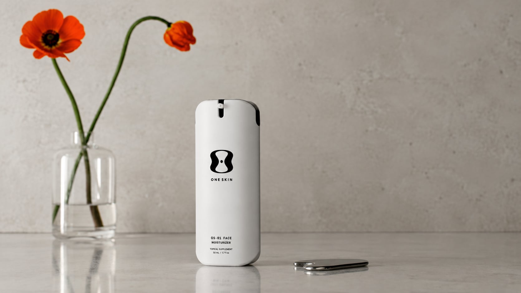 OS-01 Face Moisturizer on a stone counter with a poppy
